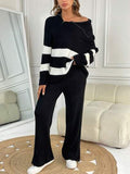 A cozy black knit sweater featuring wide white stripes on the sleeves and body, designed with a relaxed fit and off-shoulder neckline for a casual yet stylish look. - M