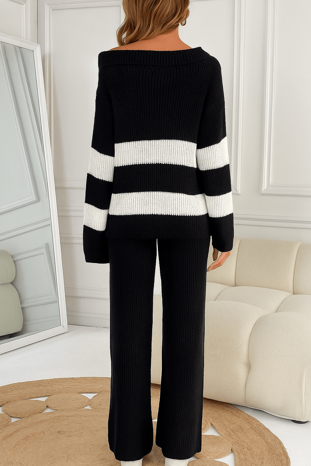A cozy black knit sweater featuring wide white stripes on the sleeves and body, designed with a relaxed fit and off-shoulder neckline for a casual yet stylish look. - M