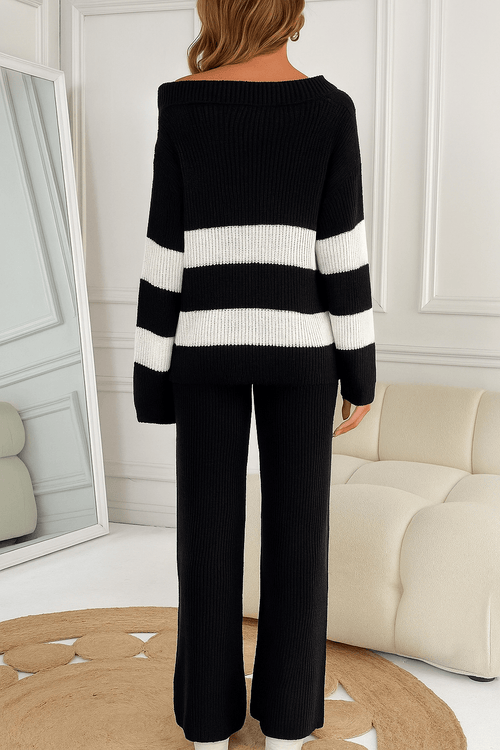A cozy black knit sweater featuring wide white stripes on the sleeves and body, designed with a relaxed fit and off-shoulder neckline for a casual yet stylish look. - M